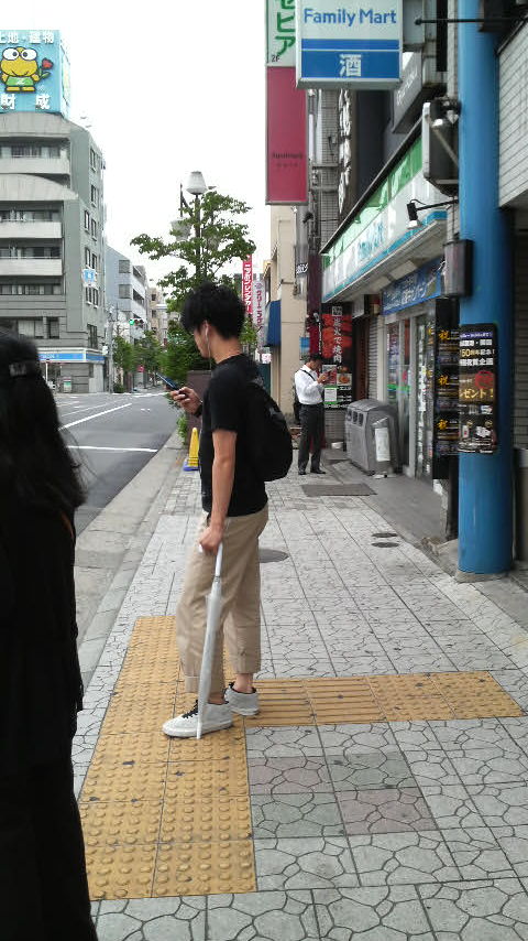 Indian man in Ichinoe in Edogawa Ward, Tokyo, Japan (he is the one wearing a white shirt standing next to the convenience store bins.)