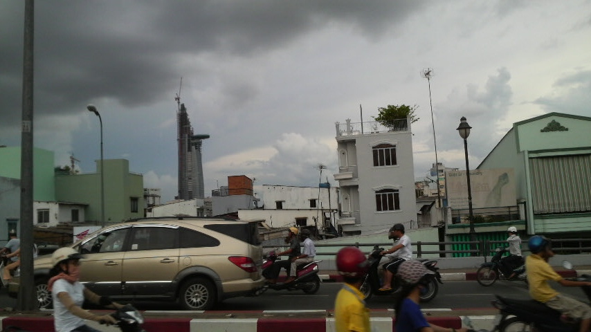 Half completed Bitexco Building photographed from a bridge crossing the river from District 1 to District 4.