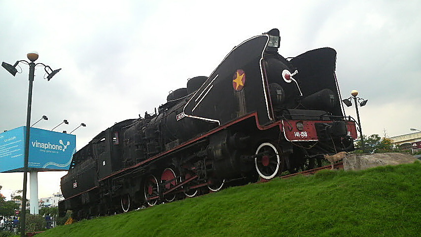 Old train engine on proud display outside Saigon Railway Station, Vietnam