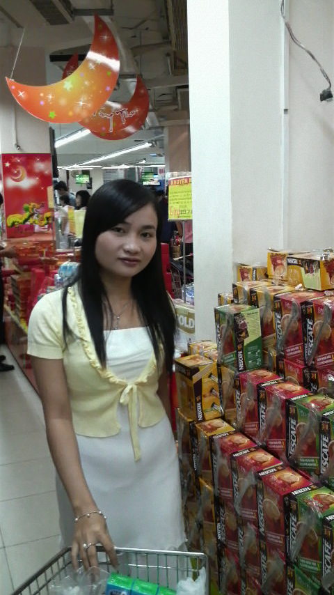 Nga in the coffee and milk goods section of local Coop Mart, a bundle of green tea flavored milk cartons in her trolley