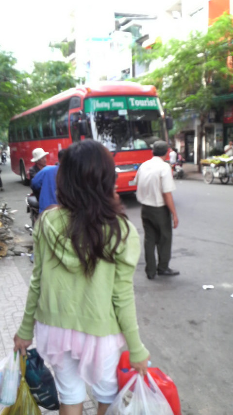 Nga with her inevitable bags of milk and fruit and stuff at the busport near Sinh Cafe in backpacker Saigon