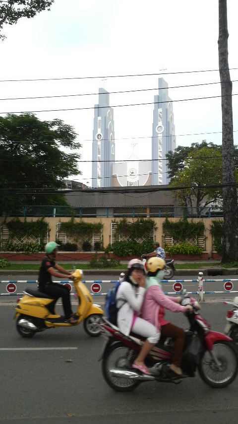 Twin spires and clockface of a church under construction near the Saigon Racetrack.